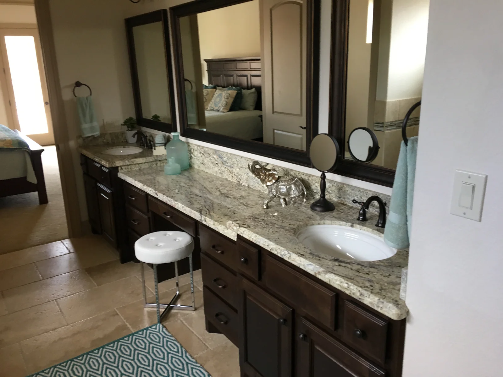 Double vanity with dark wood cabinets, granite countertop, undermount sinks, and bronze faucets in a bathroom